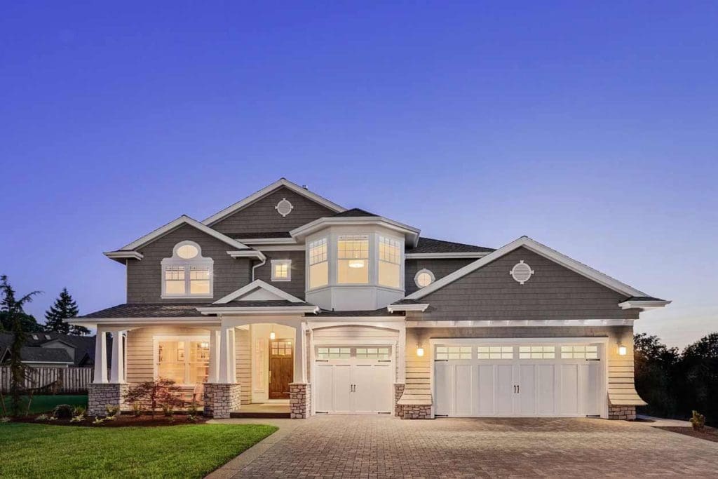 A large house with two garage doors and a porch.