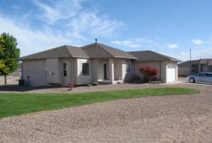 A house with a driveway and grass in front of it.