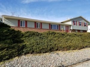 A house with bushes and rocks in front of it