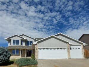 A large white house with two garage doors.