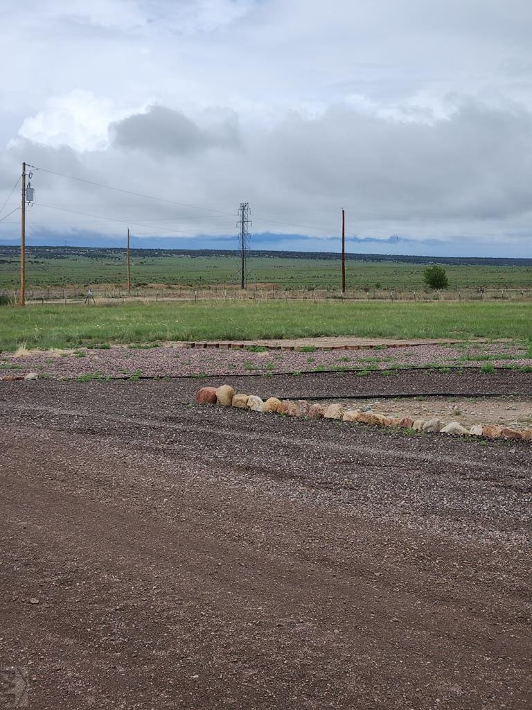 Gravel path with power lines and mountains.