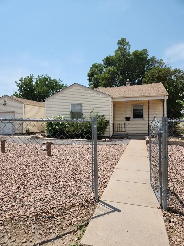 Yellow house with a concrete walkway.