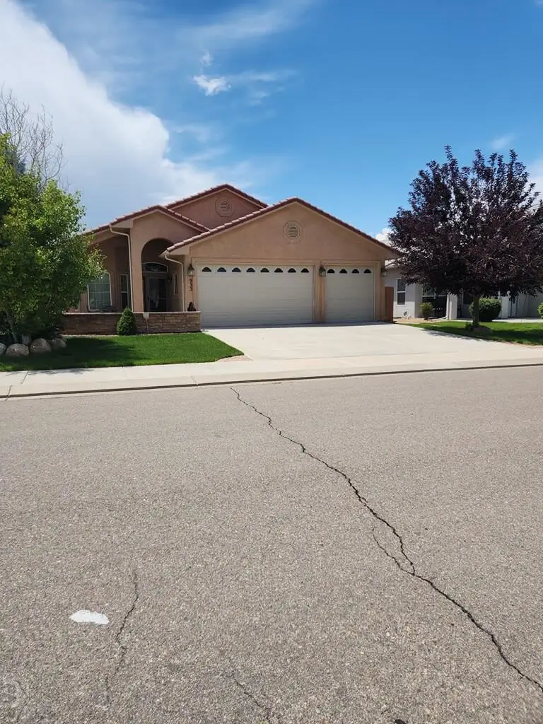 Tan house with three garage doors.